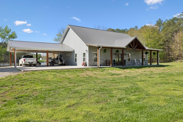 208 Lakeview Dr, Hohenwald, TN 38462 - back of house with a lawn, metal roof, stone siding, and gravel driveway