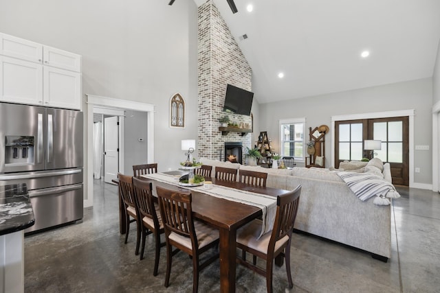 208 Lakeview Dr, Hohenwald, TN 38462 - dining area with high vaulted ceiling, finished concrete flooring, a brick fireplace, baseboards, and recessed lighting