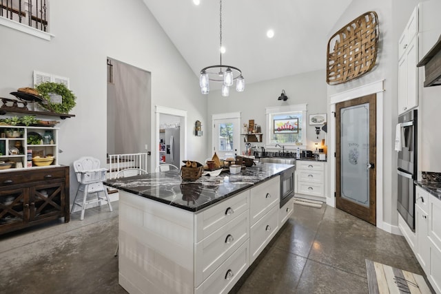 208 Lakeview Dr, Hohenwald, TN 38462 - kitchen featuring high vaulted ceiling, stainless steel appliances, white cabinets, a center island, and pendant lighting