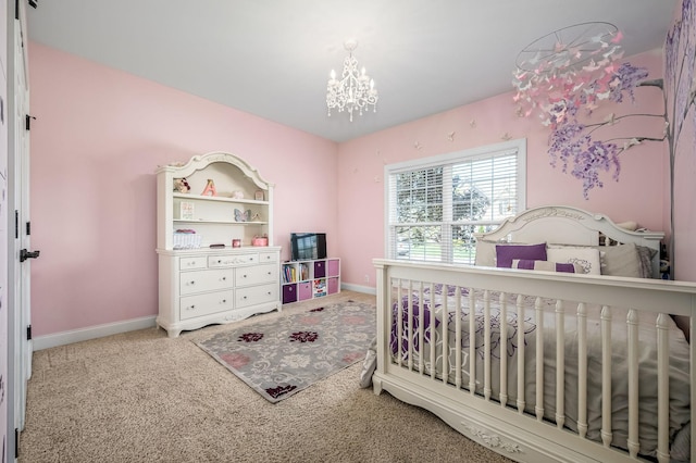 carpeted bedroom featuring a notable chandelier and baseboards