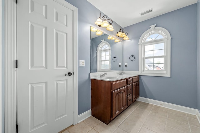 full bath with visible vents, baseboards, a sink, double vanity, and tile patterned flooring
