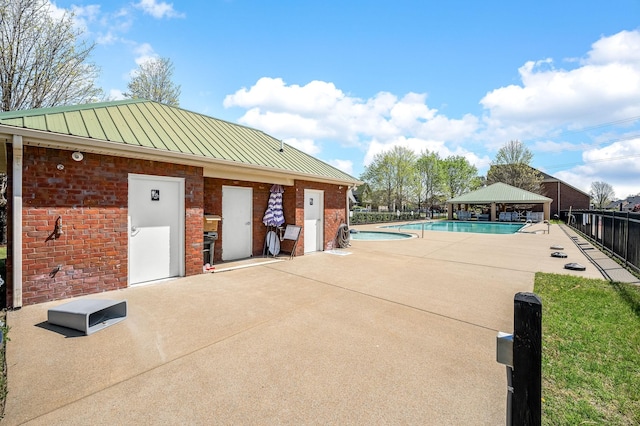 community pool with a gazebo, fence, and a patio