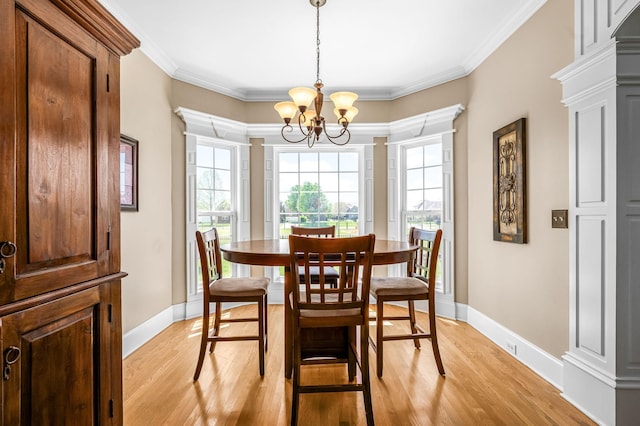 dining room featuring a chandelier, light wood finished floors, and ornamental molding