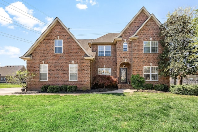 traditional-style home featuring brick siding and a front lawn