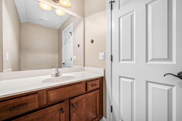 bathroom featuring visible vents, vanity, and vaulted ceiling