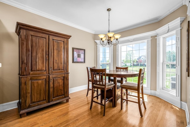 dining space featuring baseboards, a notable chandelier, light wood-type flooring, and crown molding
