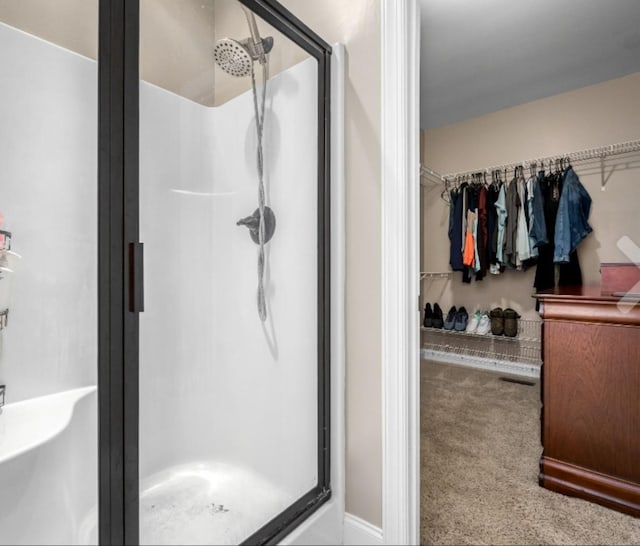 bathroom featuring visible vents, a walk in closet, and a stall shower