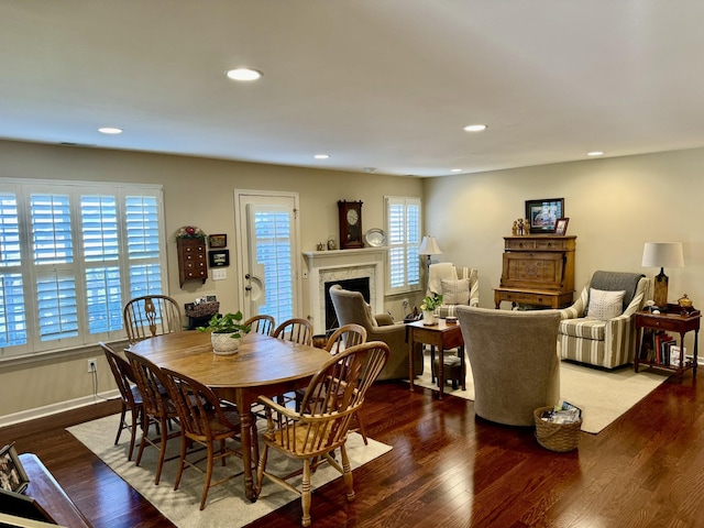 dining space featuring wood finished floors, a fireplace, and recessed lighting