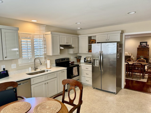 kitchen with a sink, light countertops, under cabinet range hood, recessed lighting, and stainless steel appliances