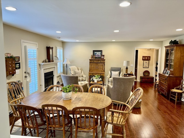 dining room with recessed lighting, a fireplace, and dark wood finished floors