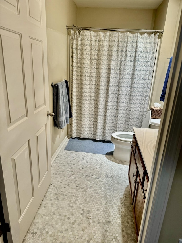 bathroom with toilet, vanity, and a shower with shower curtain