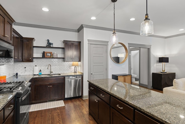 kitchen featuring appliances with stainless steel finishes, a sink, ornamental molding, and dark brown cabinetry