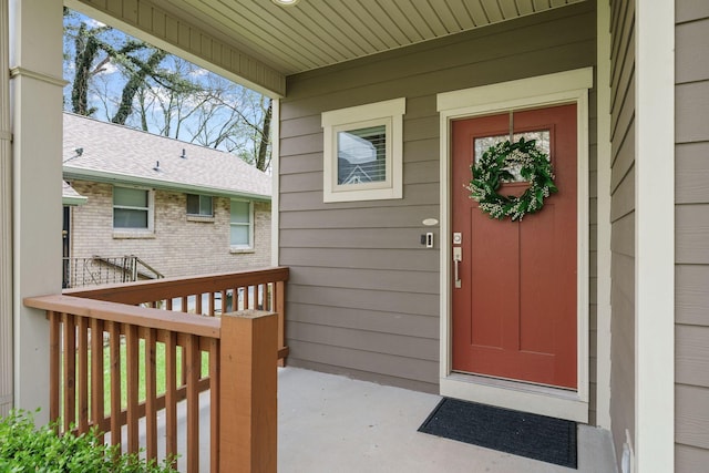 doorway to property featuring a shingled roof
