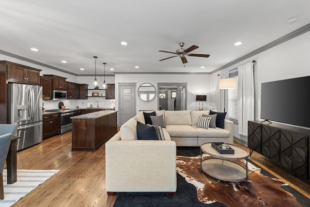 living room with crown molding, recessed lighting, a ceiling fan, and wood finished floors