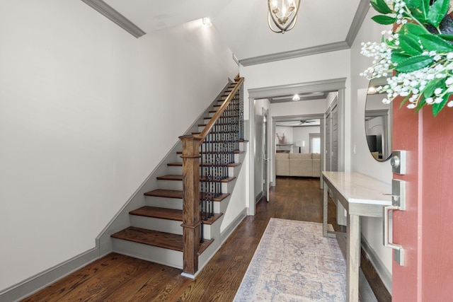 entrance foyer with dark wood-type flooring, crown molding, baseboards, and stairway