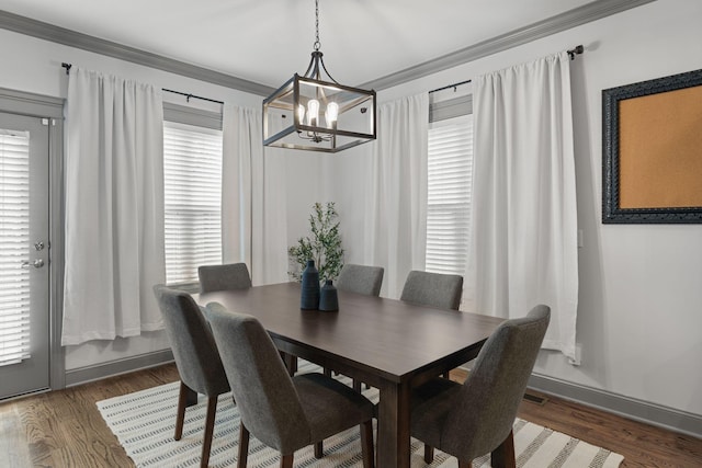 dining space featuring crown molding, a notable chandelier, wood finished floors, and a healthy amount of sunlight