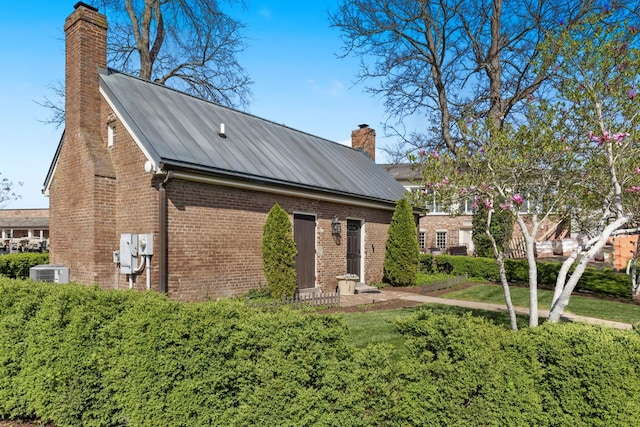 763 Plantation Way, Gallatin, TN 37066 - rear view of house featuring central AC unit, a yard, metal roof, a chimney, and brick siding