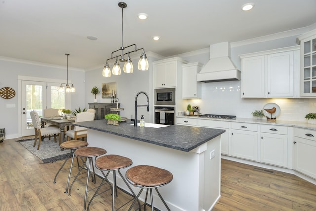 kitchen with custom exhaust hood, crown molding, backsplash, appliances with stainless steel finishes, and a sink