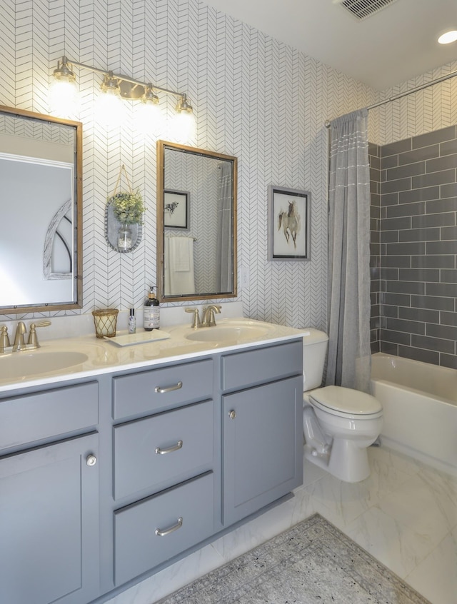 full bathroom with double vanity, marble finish floor, a sink, and toilet