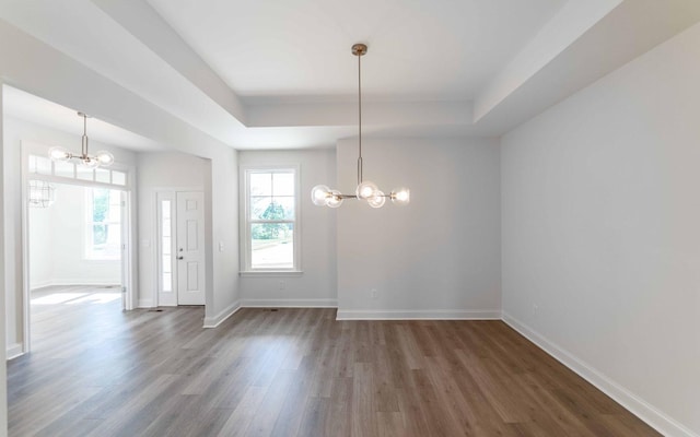 7705 Pine St, Fairview, TN 37062 - unfurnished dining area with a chandelier, a tray ceiling, wood finished floors, and baseboards