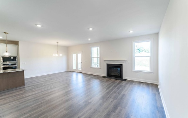 7705 Pine St, Fairview, TN 37062 - unfurnished living room featuring healthy amount of natural light, a fireplace with flush hearth, baseboards, recessed lighting, and dark wood-style flooring