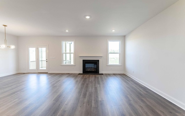 7705 Pine St, Fairview, TN 37062 - unfurnished living room featuring dark wood-style floors, a fireplace with flush hearth, baseboards, a chandelier, and recessed lighting