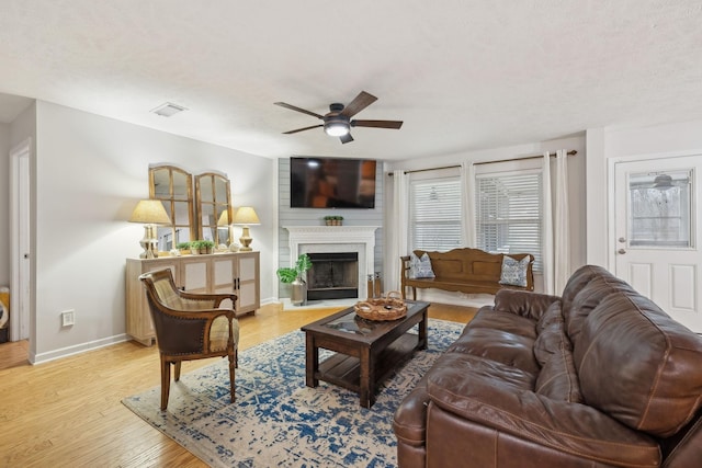 1006 Harmony Ln, Hendersonville, TN 37075 - living area featuring light wood-type flooring, baseboards, a fireplace, visible vents, and ceiling fan
