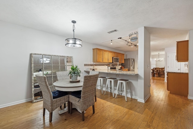 1006 Harmony Ln, Hendersonville, TN 37075 - dining space with visible vents, baseboards, a notable chandelier, a textured ceiling, and light wood finished floors