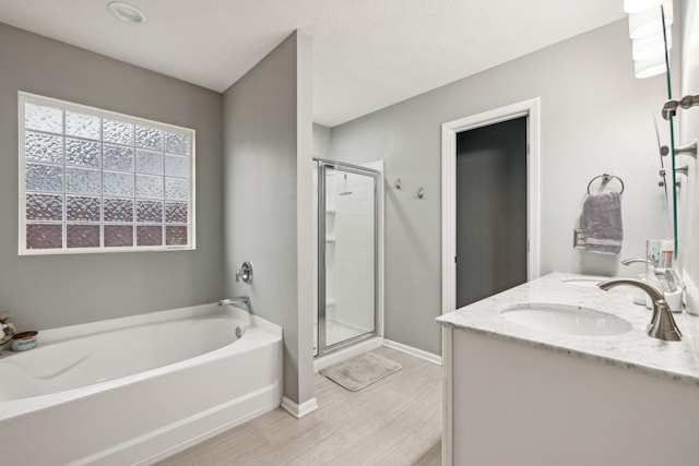1006 Harmony Ln, Hendersonville, TN 37075 - bathroom with a shower stall, a bath, wood finished floors, a sink, and baseboards