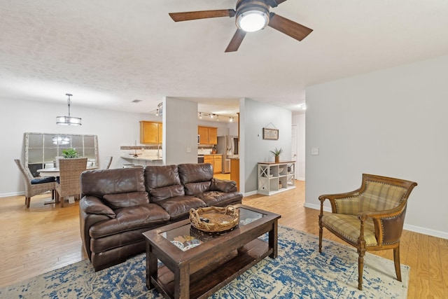 1006 Harmony Ln, Hendersonville, TN 37075 - living room featuring track lighting, ceiling fan with notable chandelier, light wood finished floors, and baseboards