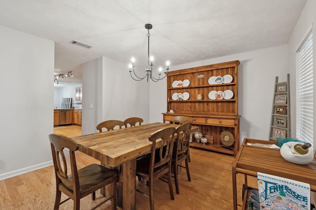 1006 Harmony Ln, Hendersonville, TN 37075 - dining area featuring baseboards, an inviting chandelier, light wood-style flooring, a textured ceiling, and visible vents