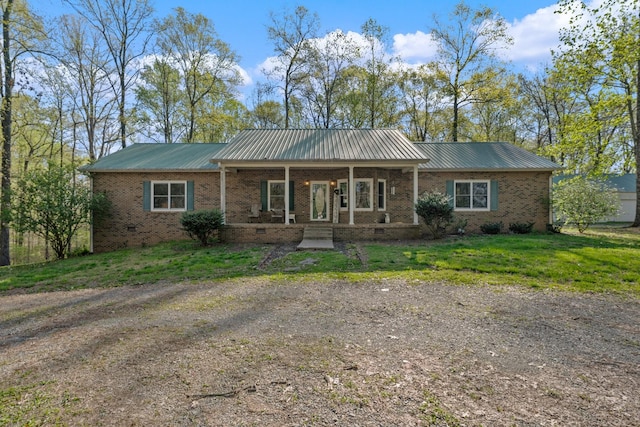 view of front facade featuring crawl space, brick siding, a front yard, and metal roof
