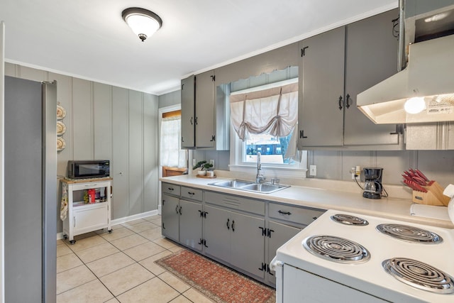 kitchen with black microwave, freestanding refrigerator, exhaust hood, white range with electric stovetop, and a sink