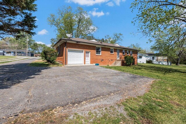 ranch-style house with brick siding, a front yard, a garage, and aphalt driveway