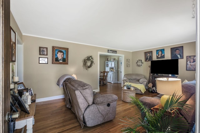 living room featuring baseboards, ornamental molding, and wood finished floors