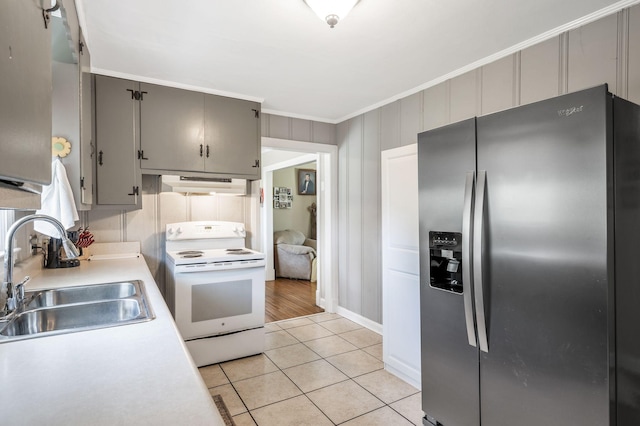 kitchen featuring stainless steel refrigerator with ice dispenser, electric stove, a sink, and gray cabinets