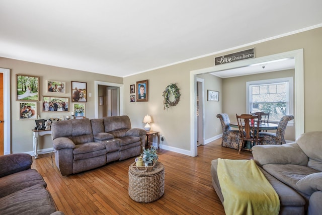 living area with hardwood / wood-style flooring, baseboards, and crown molding