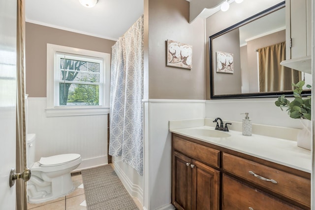 full bathroom with vanity, ornamental molding, toilet, wainscoting, and tile patterned floors