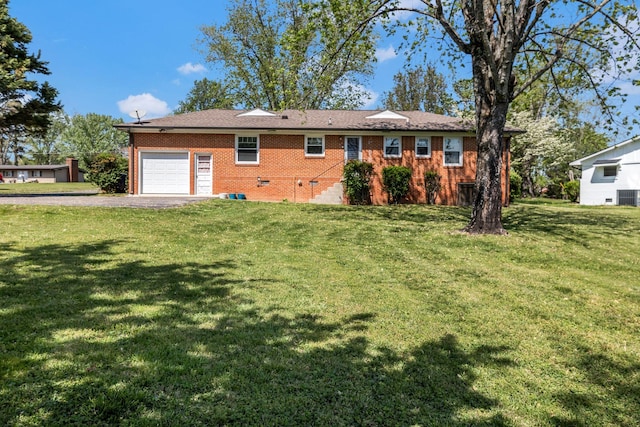 view of front of home with central air condition unit, a front yard, brick siding, an attached garage, and driveway