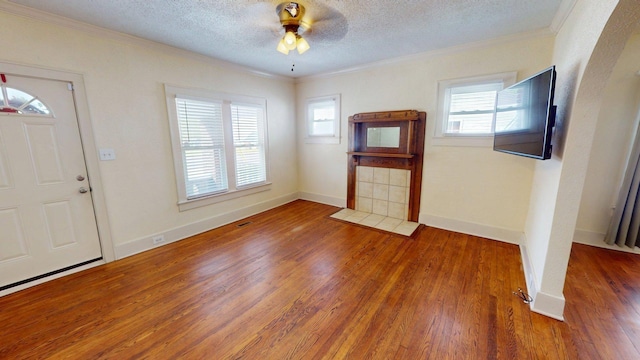 foyer featuring crown molding, wood finished floors, a ceiling fan, and a textured ceiling