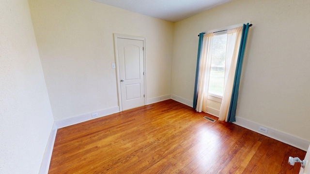 empty room with visible vents, baseboards, and light wood-style floors