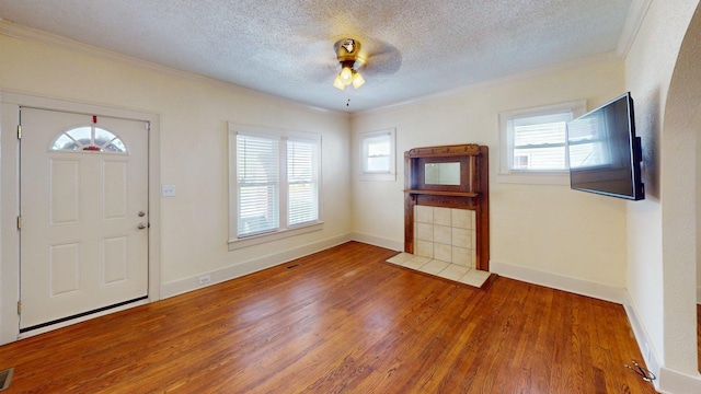 entryway featuring wood finished floors, ornamental molding, and a wealth of natural light