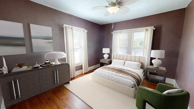 bedroom featuring baseboards, wood finished floors, and ceiling fan