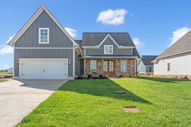 view of front of home featuring stone siding, board and batten siding, french doors, a front lawn, and driveway