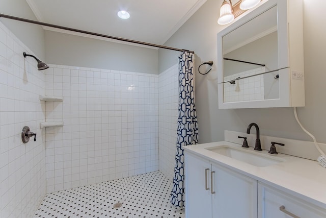 bathroom with vanity, a tile shower, and crown molding