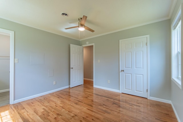 unfurnished bedroom with visible vents, baseboards, ornamental molding, and light wood-style flooring