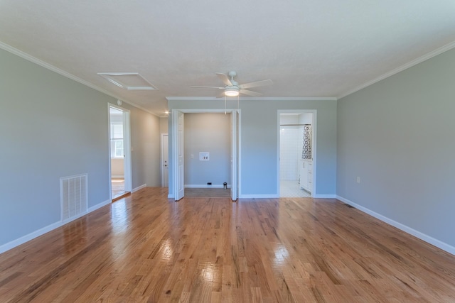 interior space with attic access, visible vents, crown molding, and light wood-style flooring