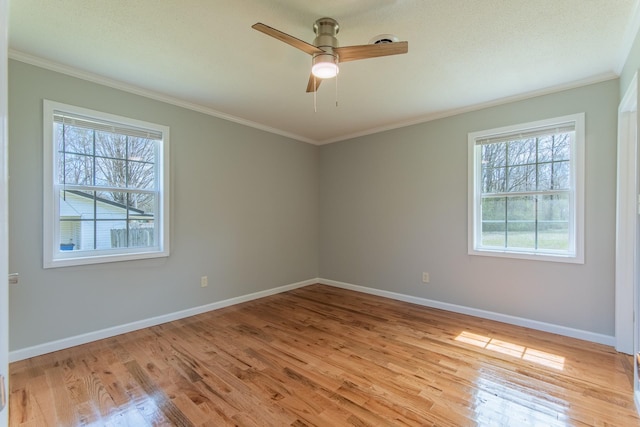 unfurnished room with light wood finished floors, ornamental molding, and plenty of natural light