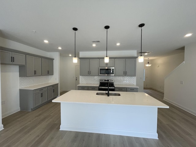 kitchen with gray cabinets, appliances with stainless steel finishes, a sink, and visible vents