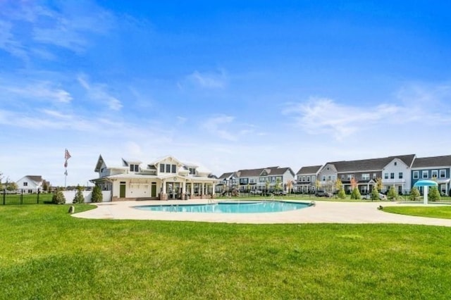 view of pool with a fenced in pool, a patio, a residential view, fence, and a lawn